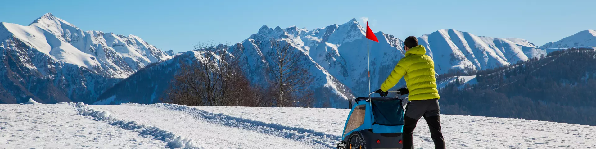 Hiker in the mountains pushing a stroller in the snow