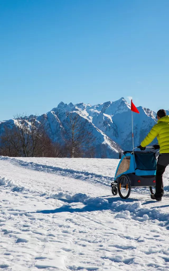 Hiker in the mountains pushing a stroller in the snow