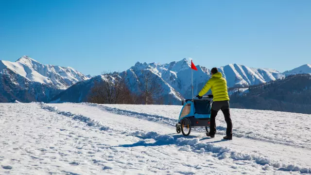 Hiker in the mountains pushing a stroller in the snow