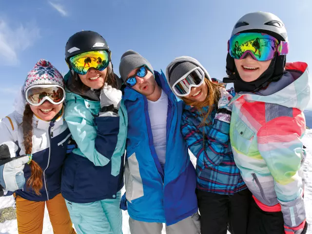 Group of friends snowboarders having fun on the top of mountain in Sheregesh resort