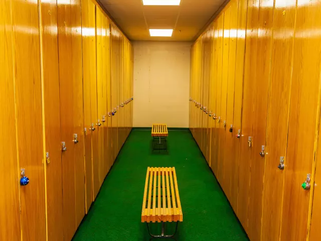 A bench in the middle of a locker room.