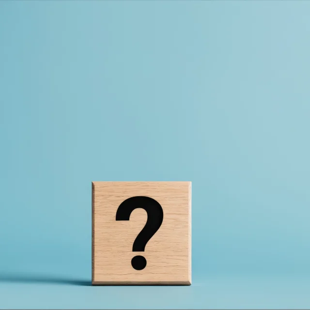 Question mark on wooden block against blue background